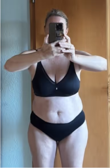 Eine Frau in schwarzer Unterwäsche macht ein Selfie im Spiegel.