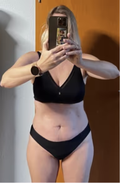 Eine Frau in schwarzer Unterwäsche macht ein Selfie im Spiegel.