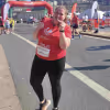 WPF Community - Eine lächelnde Frau in rotem T-Shirt und schwarzen Leggings beim Laufen.