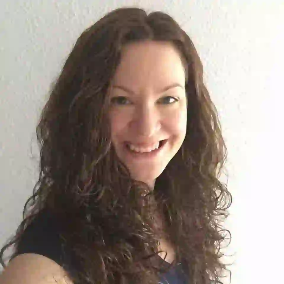WPF Community - Eine lächelnde Frau mit langen, lockigen braunen Haaren.